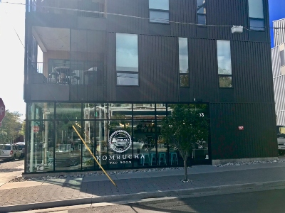 Photo of front of building at 3233 Tejon St in Denver, showing a windowed Kombucha tasting room. This space is available for sublease.